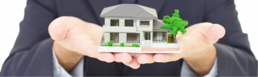 手のひらに戸建ての模型を乗せている様子