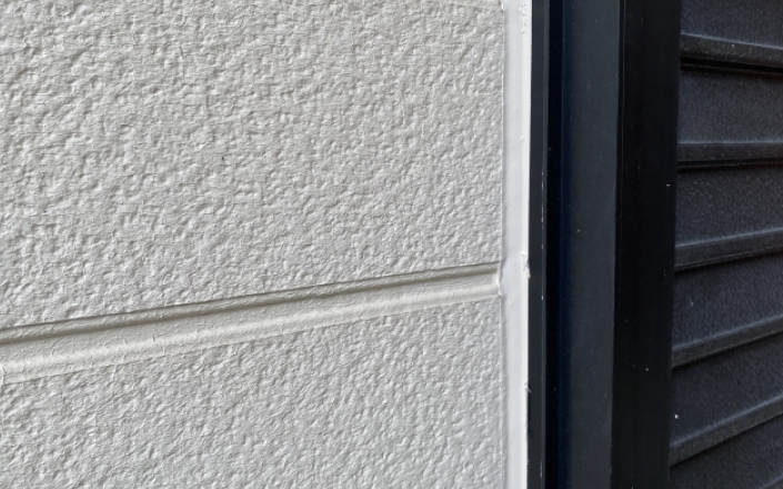 窓サッシのコーキングを確認している様子