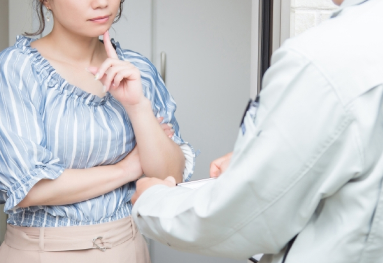 悩んでいる女性と説明する業者の様子