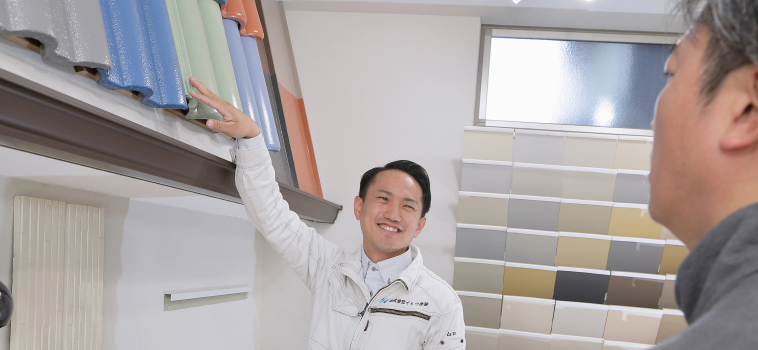 お客様に屋根のサンプルをご覧いただいている様子