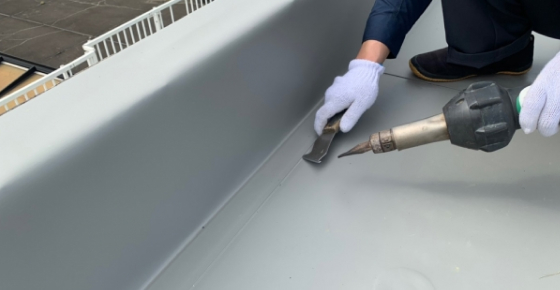 工具を手に防水工事をする様子