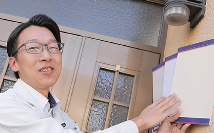 外壁にカラーサンプルを当てている様子