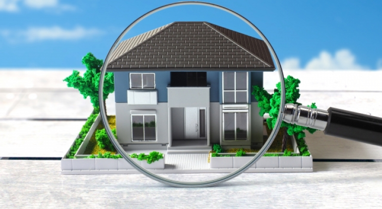 模型でできた戸建てを虫眼鏡で見ている様子